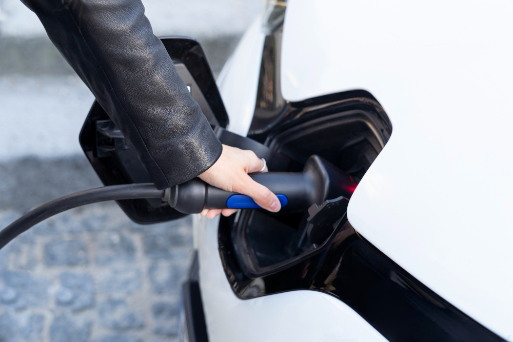 Femme rechargeant sa voiture électrique à une borne de recharge